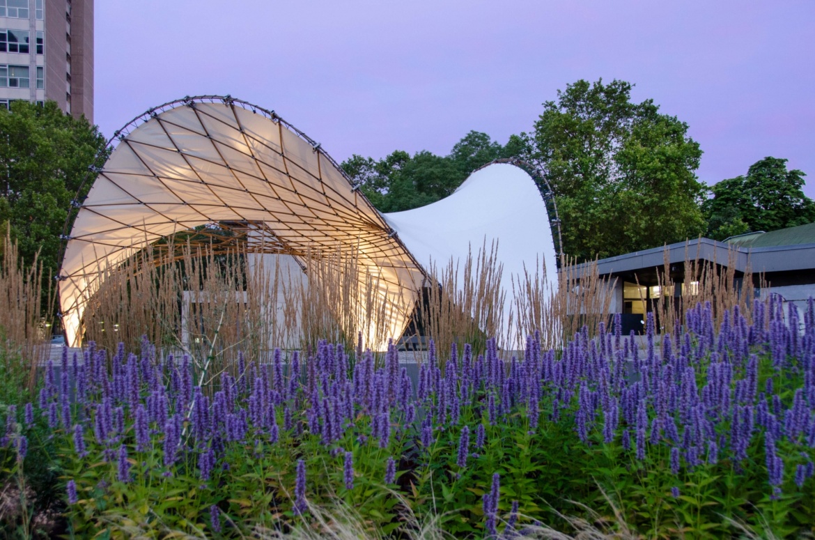 BioMat Pavillon hinter einem Blumenbeet